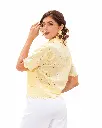 Retrato de moda con blusa amarilla y pendientes dorados.webp