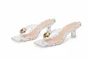 Sandalias transparentes con adorno dorado.webp